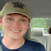 Exercise science student Zach Jordan, wearing a baseball cap and sitting in a car.